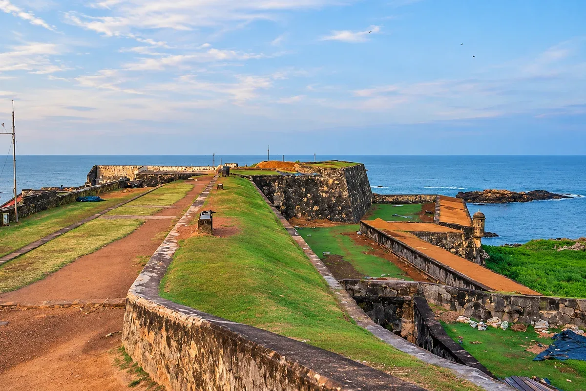 Stone fort walls and grassy walking paths overlooking the sea in Galle