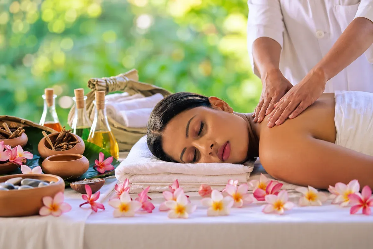 A therapist giving a shoulder massage in a garden spa